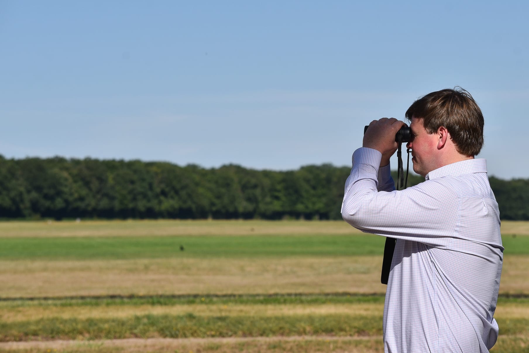 Gavin Hernon watching work through binoculars at the Chantilly gallops